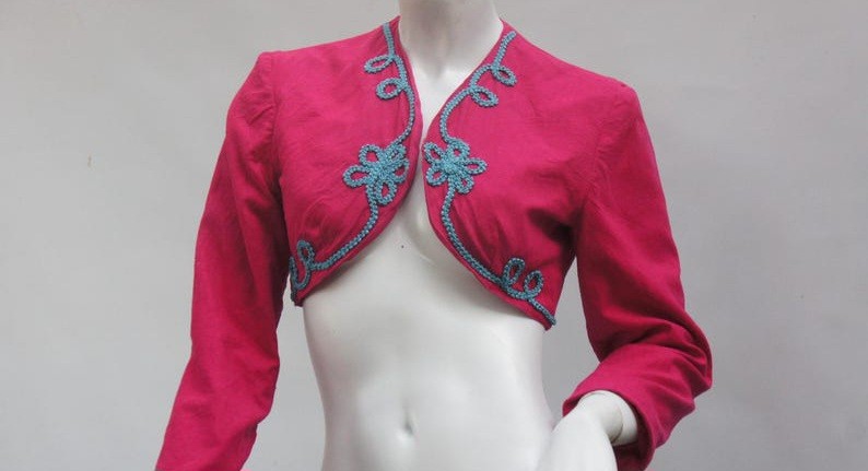 a dark pink bolero shrug with light blue floral embroidery