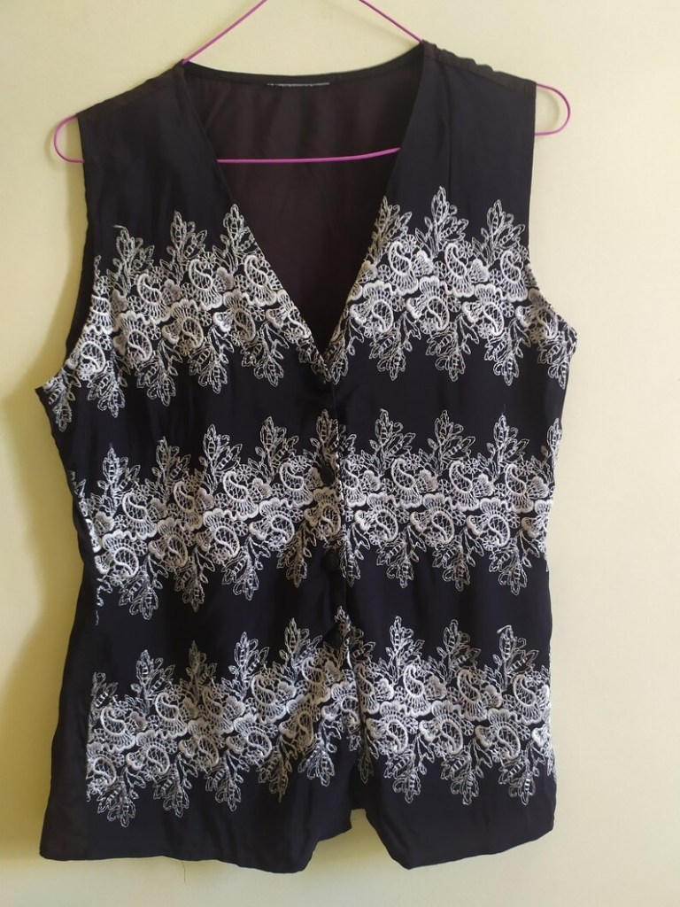 a back vest with white plantlike embroidery 